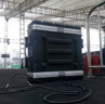 A large black equipment case with cables attached sits on a stage under a tent. Metal railings and a person in the background are visible. {{brizy_dc_image_alt imageSrc=