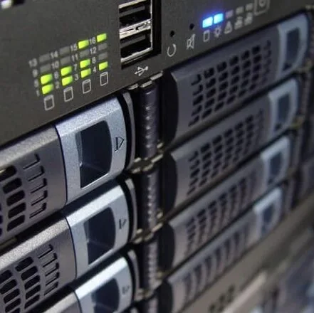Close-up of the front panel of a server rack showing multiple hard drive bays, indicator lights, USB ports, and ventilation grilles. {{brizy_dc_image_alt imageSrc=